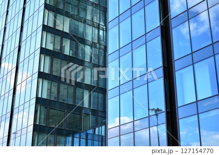 Modern sustainable glass office buildings. Exterior view of corporate headquarters glass buildings architecture.Glass windows in energy-efficient buildings. Financial business center buildings. Modern sustainable glass office buildings. Exterior view of corporate headquarters glass buildings architecture.Glass windows in energy-efficient buildings. Financial business center buildings. 127154770