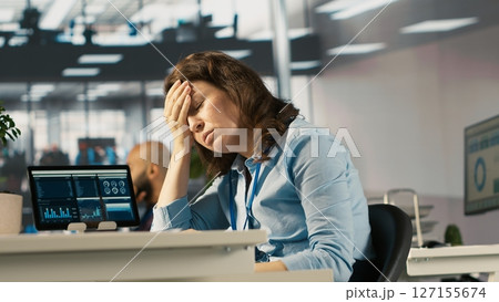 Upset employee in office dejected by bad news after reading negative email from business partner. Dejected worker frowning after failed client acquisition attempt, camera A Upset employee in office dejected by bad news after reading negative email from business partner. Dejected worker frowning after failed client acquisition attempt, camera A 127155674