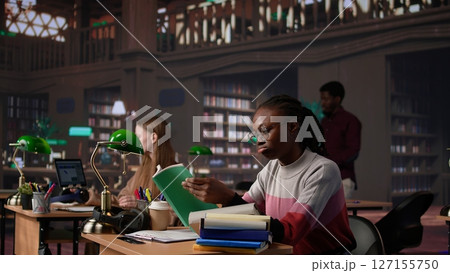 Confident student gathers information and citations from reliable sources via massive database at university library, working on bachelor degree paper. Intelligent girl studies. Camera B. Confident student gathers information and citations from reliable sources via massive database at university library, working on bachelor degree paper. Intelligent girl studies. Camera B. 127155750