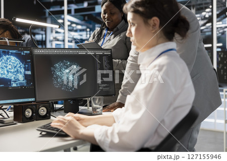Data center team of programmers using artificial intelligence neural networks technology. Server farm coworkers using AI programming language on computer to update equipment 127155946