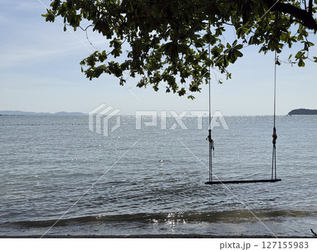 Breathtaking wooden swing found on an exotic beach in Thailand, amazing picturesque landscape of a beach front and lagoon in the evening. Lovely tropical scenery with waves crashing. Breathtaking wooden swing found on an exotic beach in Thailand, amazing picturesque landscape of a beach front and lagoon in the evening. Lovely tropical scenery with waves crashing. 127155983