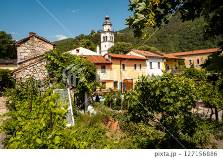 Charming Townscape Of Vipava With Castle View: Colorful Historic Houses And Church Tower Nestled Below Forested Hills With Distant Castle Ruins Under A Clear Blue Sky In Western Slovenia Charming Townscape Of Vipava With Castle View: Colorful Historic Houses And Church Tower Nestled Below Forested Hills With Distant Castle Ruins Under A Clear Blue Sky In Western Slovenia 127156886