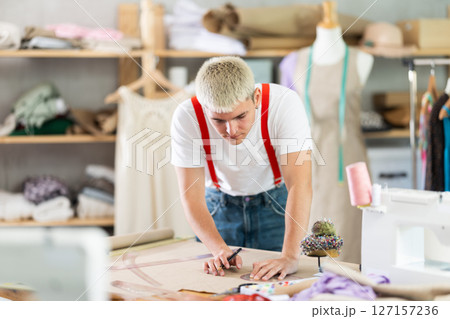 Male fashion designer draws with curved rulers Male fashion designer draws with curved rulers 127157236