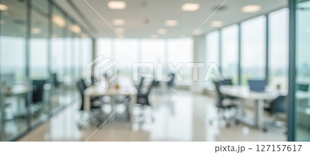 Bright blurred office background with glass walls and desks in modern coworking space for business presentation or digital design use 127157617