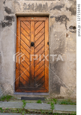 Old Wooden Door on Weathered Stone Wall 127158446