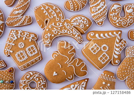 Gingerbread decorated with white sugar glaze. Food background. Christmas cookies. Gingerbread decorated with white sugar glaze. Food background. Christmas cookies. 127158486