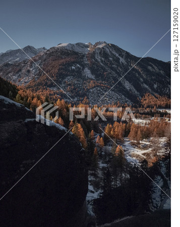 Warm autumn sunlight casts a golden glow on the snow dusted mountains and forests of aosta, italy, creating a picturesque november landscape Lillaz Warm autumn sunlight casts a golden glow on the snow dusted mountains and forests of aosta, italy, creating a picturesque november landscape Lillaz 127159020