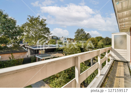 A serene outdoor view showcasing lush greenery framed by modern architecture, highlighting tranquility and urban life coexisting harmoniously. 127159517