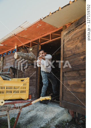 boy loads wood into wheelbarrow 127159702