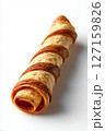 Flaky pastry roll lies on clean white surface, showcasing its crispy texture and golden layers. This minimalist aesthetic highlights culinary artistry, ideal for bakery, catering, dessert shop 127159826