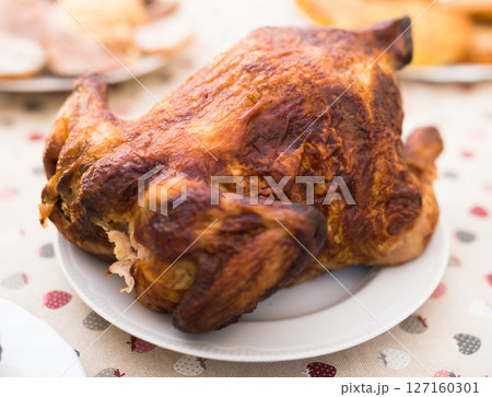 Whole roasted chicken on a plate 127160301