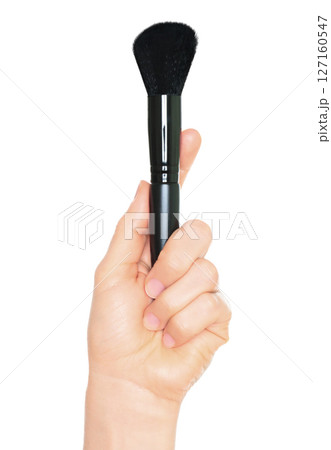 Woman hand holds black cosmetics brush, isolated on transparent background, cosmetics and visage concept Woman hand holds black cosmetics brush, isolated on transparent background, cosmetics and visage concept 127160547