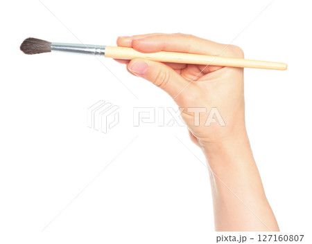 Woman hand holds paint brush, isolated on transparent background, painting and design concept 127160807