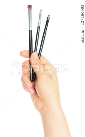 Woman hand holds Cosmetics Brushes, isolated on transparent background, cosmetics and visage concept Woman hand holds Cosmetics Brushes, isolated on transparent background, cosmetics and visage concept 127160992
