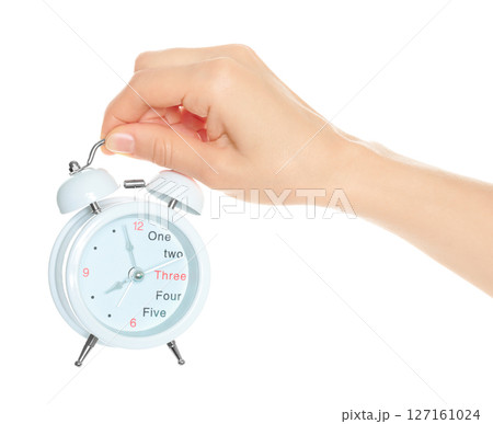 Woman hand holds white Alarm Clock, isolated on transparent background, time and home things concept Woman hand holds white Alarm Clock, isolated on transparent background, time and home things concept 127161024