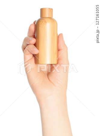 Woman hand holds a wooden cosmetic bottle, on transparent background close-up, template for cosmetics ads 127161055