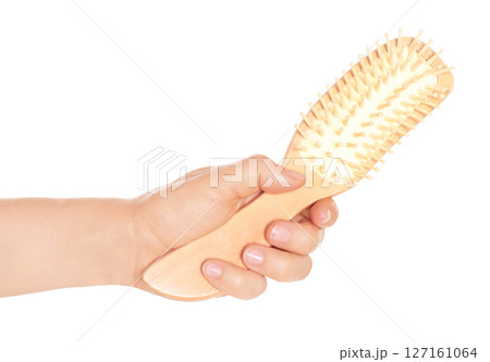 Woman hand holds hairbrush, isolated on transparent background, visage concept 127161064