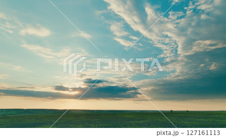 A Serene Landscape at Dusk Featuring an Expansive Sky with Beautiful Clouds Present 127161113