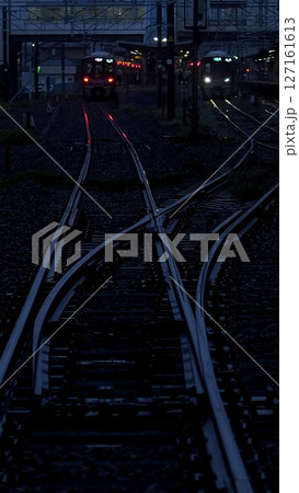梅雨の景色、レールに反射する駅の灯り 127161613
