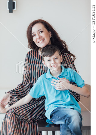 Mom hugging little son and smiling Mom hugging little son and smiling 127162115