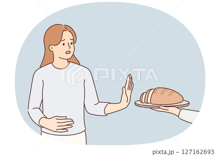 Frustrated woman holding on to stomach refuses bread due to allergies and gluten intolerance 127162693