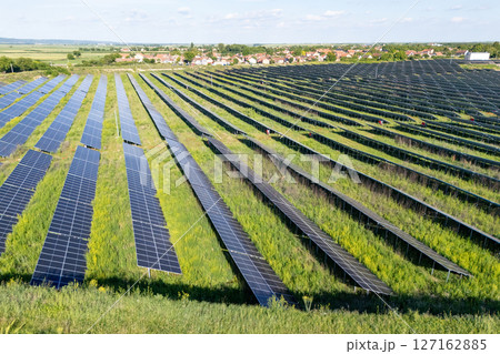 Aerial view of solar power station on a green field. Sustainable development. Aerial view of solar power station on a green field. Sustainable development. 127162885