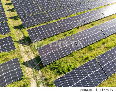 Aerial view of solar power station on a green field. Sustainable development. Aerial view of solar power station on a green field. Sustainable development. 127162915