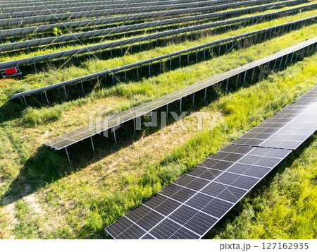 Aerial view of solar power station on a green field. Sustainable development. 127162935