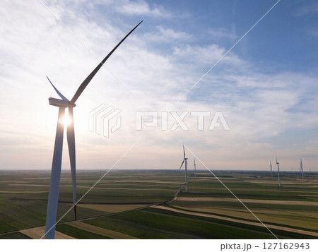Aerial view of wind turbines on an agricultural filed at sunset 127162943