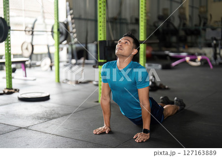 Fitness: Man Practicing Cobra Pose in Gym Fitness: Man Practicing Cobra Pose in Gym 127163889