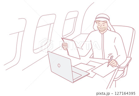 A Businessman Engaged in Work on His Laptop While Traveling on an Airplane High Above 127164395