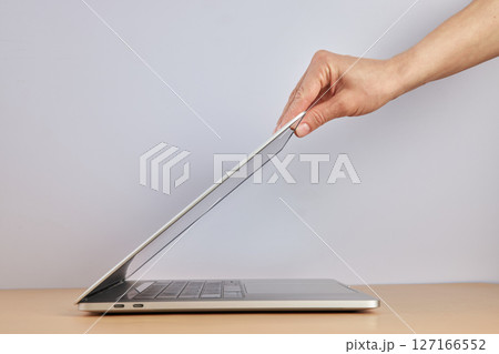 female hand open or close laptop on beige table, side view female hand open or close laptop on beige table, side view 127166552