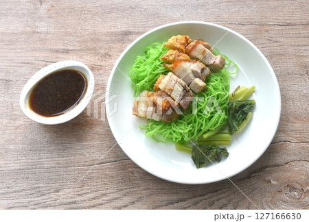 Chinese jade noodles topping roasted crispy pork dipping sweet soy sauce on plate  127166630
