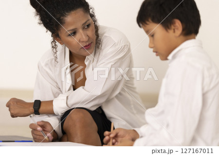 Child psychologist assisting young boy during therapy session Child psychologist assisting young boy during therapy session 127167011