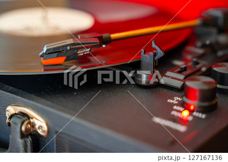 Close-up of record player needle tracking vinyl grooves during playback. Analog sound detail capturing retro music atmosphere. Close-up of record player needle tracking vinyl grooves during playback. Analog sound detail capturing retro music atmosphere. 127167136