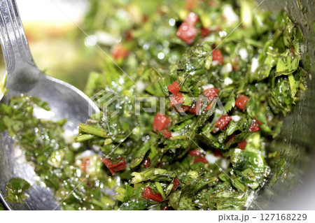 Close up of chimichurri sauce marinade with spoon in a bowl healthy 127168229
