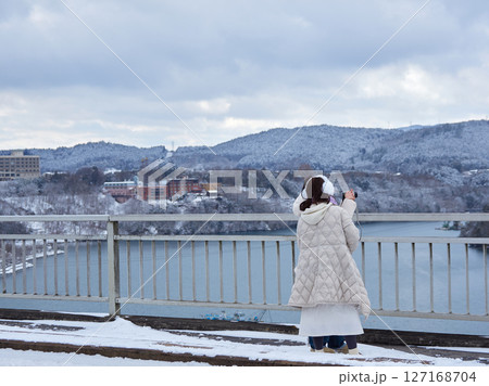 冬の日本の中部の観光名所恵那峡の橋の上で写真を撮る外国人観光客の姿 127168704
