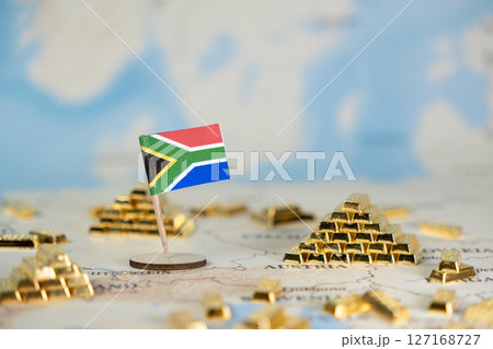 South African flag on a world map with scattered gold bar stacks, representing the nation's vast resource wealth and global economic impact, featuring copy space 127168727