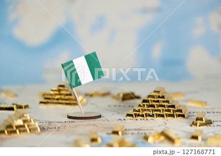 Nigerian flag stands on a global map, surrounded by gold bars symbolizing national wealth, economic strength, and abundant resources with ample copy space 127168771