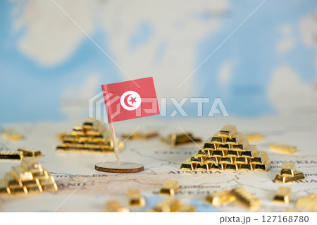 Tunisian national flag stands proudly amidst miniature gold bars on a world map, representing national economic stability, wealth, and global investment Tunisian national flag stands proudly amidst miniature gold bars on a world map, representing national economic stability, wealth, and global investment 127168780
