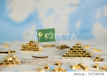 Cocos (Keeling) Islands flag stands proudly amidst shimmering gold bar piles on a world map, symbolizing global finance, national wealth, and investment strategy with ample copy space 127168790