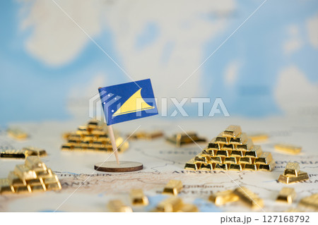 Tokelau flag on a world map with shining gold bar pyramids, symbolizing national wealth, global investment, and economic stability with copy space 127168792