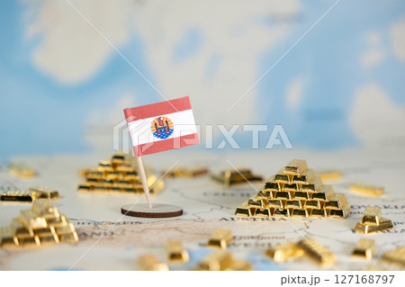 French Polynesia flag positioned on a world map surrounded by shining gold bars, symbolizing global wealth, international finance, and precious metal investment 127168797