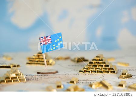 Tuvalu flag and miniature gold bars placed on a world map, symbolizing national wealth, global finance, and investment potential 127168805