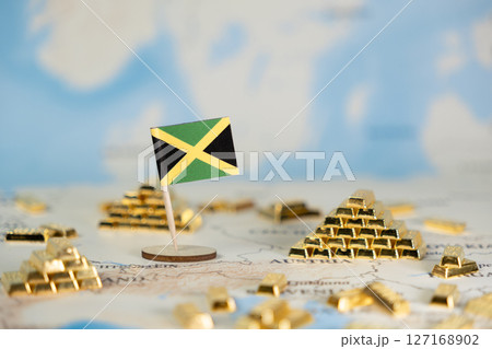 Jamaican flag on a world map, surrounded by stacks of gleaming gold bars, symbolizing national economic strength, global investment, and valuable financial assets 127168902