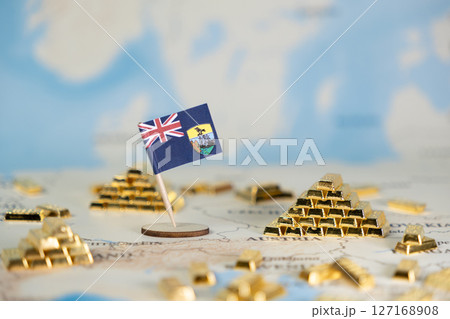 Saint Helena flag with miniature gold bars on map symbolizing overseas financial status, historical wealth, and investment potential of this British island territory Saint Helena flag with miniature gold bars on map symbolizing overseas financial status, historical wealth, and investment potential of this British island territory 127168908
