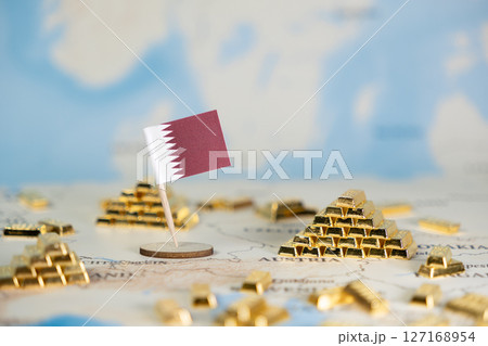 Qatar flag and golden bars on a global map illustrate national wealth, economic power, and the country's strategic financial influence with ample copy space Qatar flag and golden bars on a global map illustrate national wealth, economic power, and the country's strategic financial influence with ample copy space 127168954