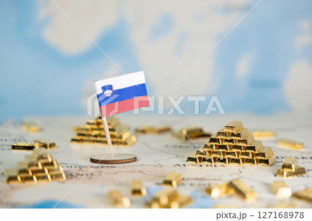 Slovenia's flag on a global map with miniature gold bars symbolizing national economic strength, financial prosperity, and resource management, ample copy space Slovenia's flag on a global map with miniature gold bars symbolizing national economic strength, financial prosperity, and resource management, ample copy space 127168978