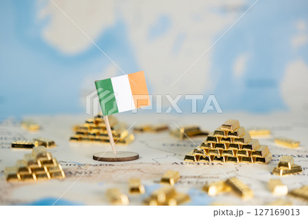 Ireland national flag on a world map with gold bars symbolizes the country's economic strength, national wealth, and financial stability, offering useful copy space 127169013