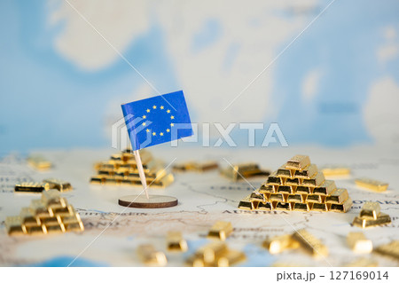 European Union flag positioned on a world map, surrounded by numerous glistening gold bar stacks, powerfully symbolizing substantial economic stability and financial wealth, offering wide copy space 127169014